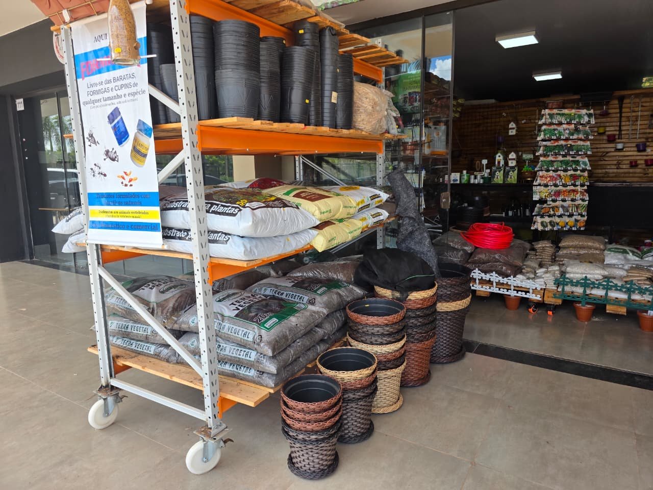 Fachada moderna da loja Hobby Verde com plantas ornamentais na entrada e letreiro verde